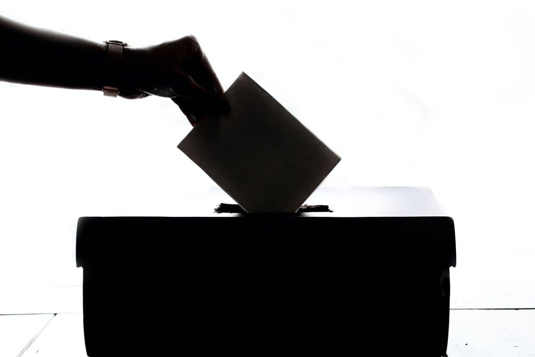 hand dropping ballot into ballot box